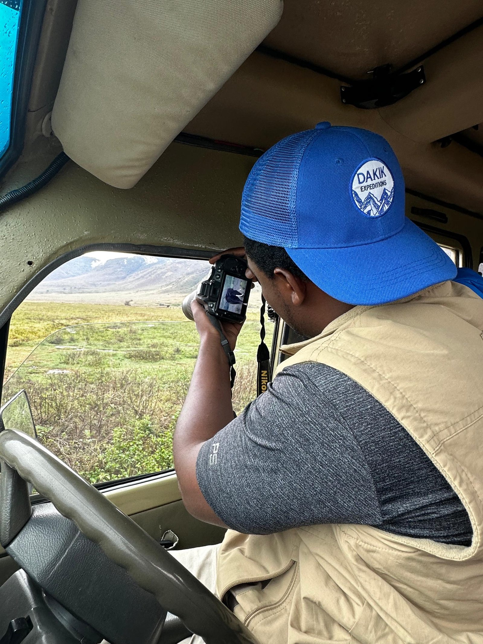 The Dakik Way, local safari guide taking a photo of the wilderness from the safari vehicle for Dakik Expeditions